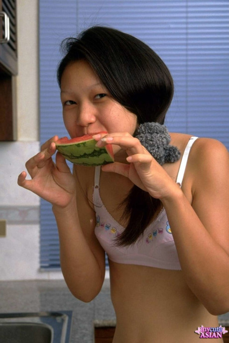 Pretty chinese teen removes lace undies while eating a watermelon
