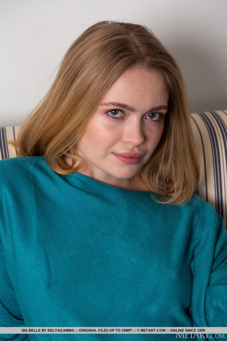 Ravishing new model Sia Belle lifts her blue pullover and warmly exposes her