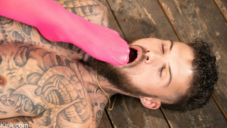 Inked babe in pink latex April Olsen abuses & mounts a tattooed man bf man in bondage