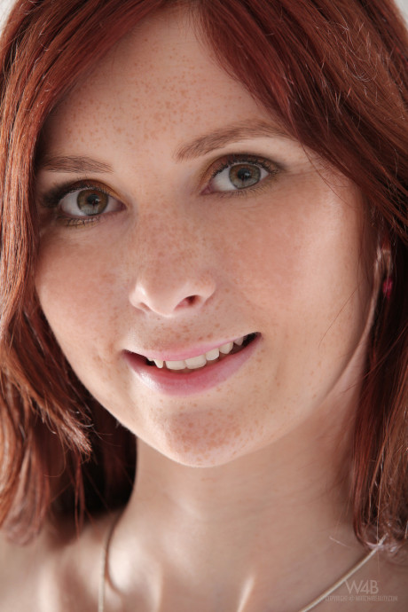Redheaded young Kattie Gold shows off her perky breasts and pink holes up close