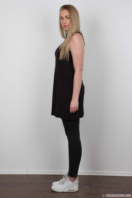 Blonde female Adela takes off her clothes while holding her face firm