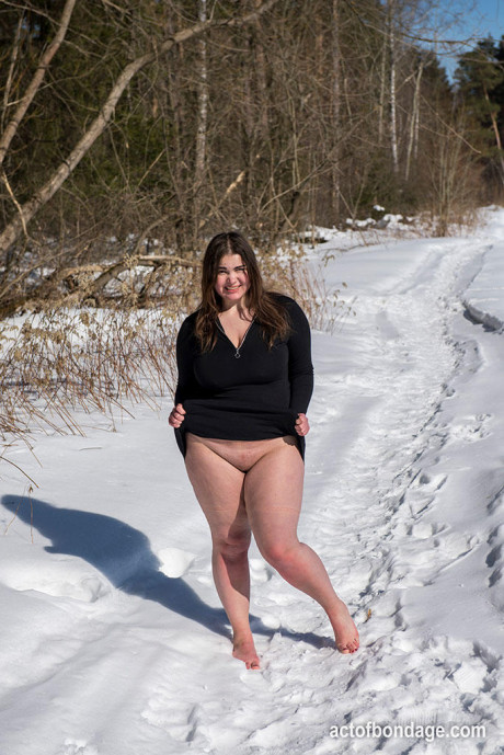 Brunette BBW rids ball gag and ropes while posing undressed and barefoot in snow