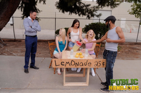 Sleazy schoolgirls give their lemonande customer a handjob in public