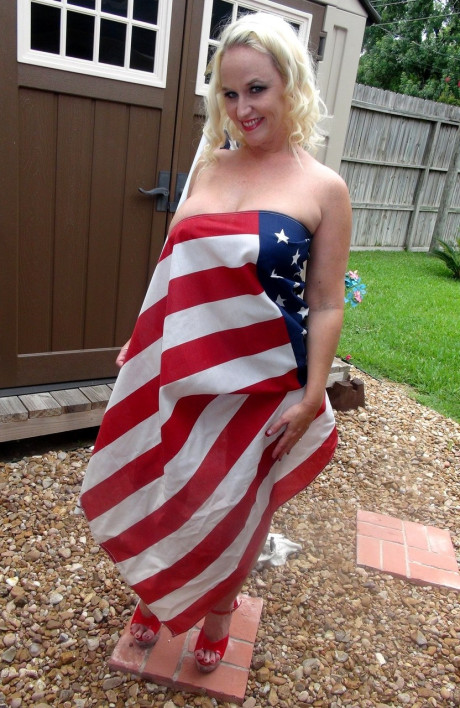 Blondy amateur Dee Siren holds an American flag while topless in a red thong