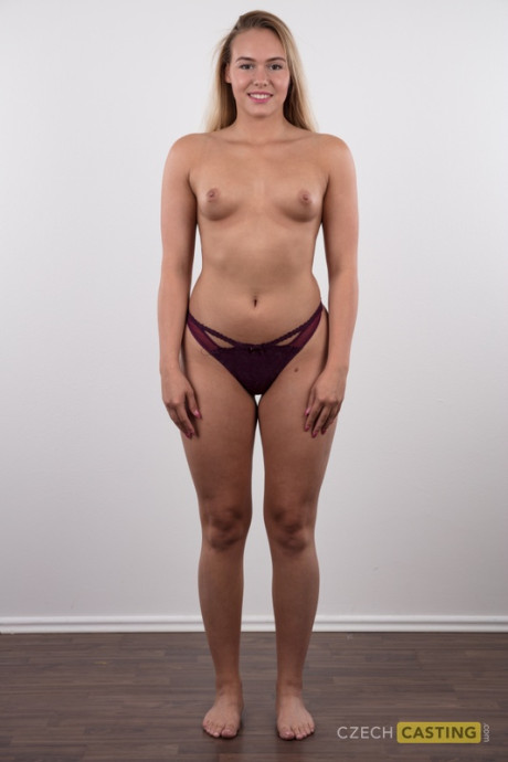 Fully clothed 18 year cougar Silvie stands behind undressed after removing her clothes
