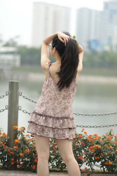 Good-looking chinese sexpot teases in a lovely short dress outdoors