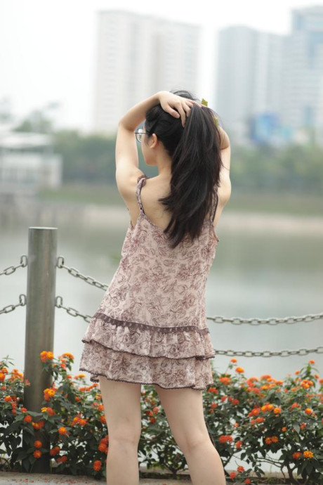 Good-looking chinese sexpot teases in a lovely short dress outdoors