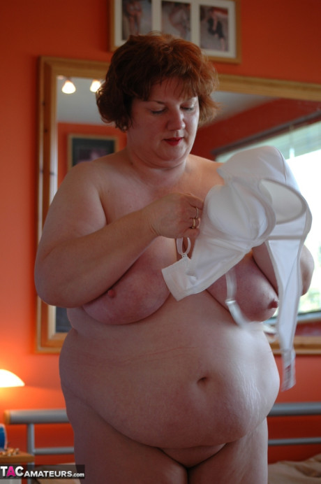 Fat amateur uncups her large boobs as she steps inside to change clothes