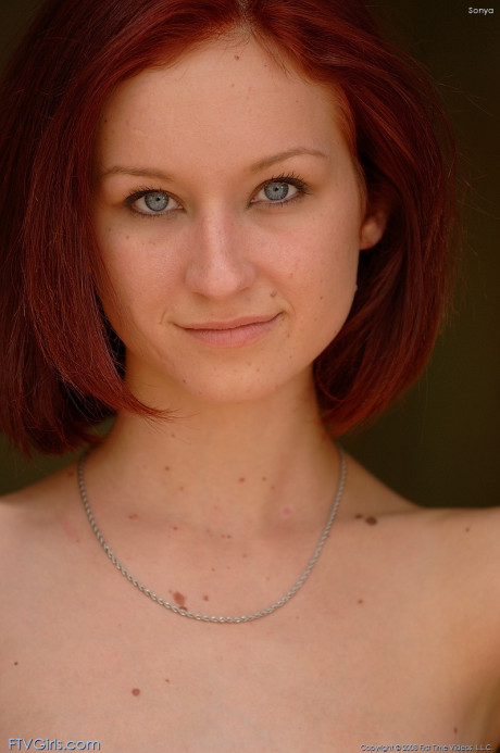 Petite red hair Sonya poses undressed and fingers her juicy twat on the floor