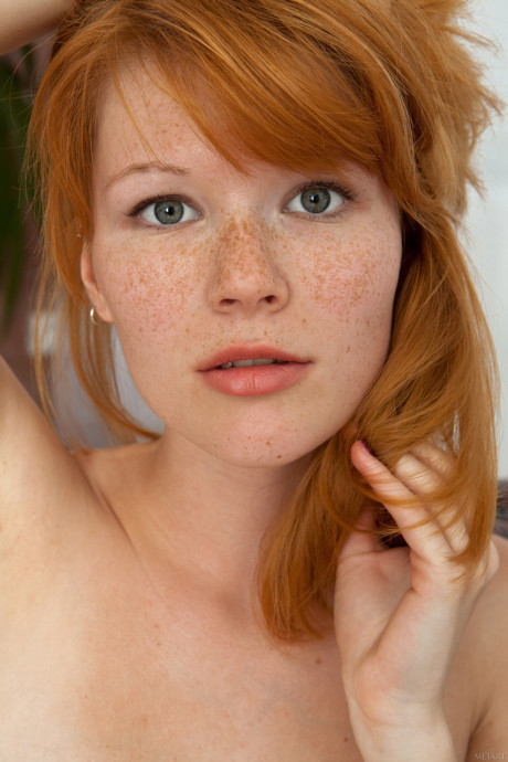 Redheaded young with nice breasts Mia Sollis poses nude in a solo