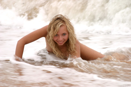 Blonde teen Alena A teases with her natural boobies and poses on the beach