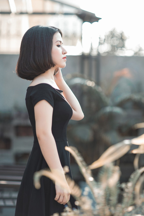 Glamorous chinese babe posing in her elegant ebony dress in public