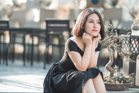 Glamorous chinese babe posing in her elegant ebony dress in public