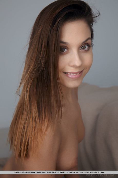 Sweet young Sabrisse A removes a sweater before showing her landing strip pussy