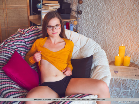 Nerdy slut girl broad Harley lights candles before getting totally undressed on a seat