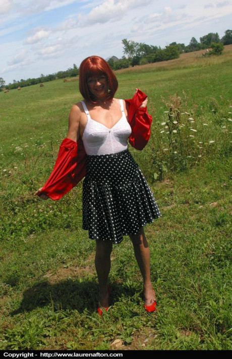 Mature redhead Lauren models a retro girdle and pantyhose in a field