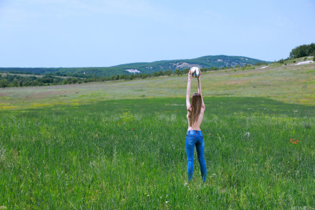 Nice teenie gets nude on a blanket while playing soccer in a field