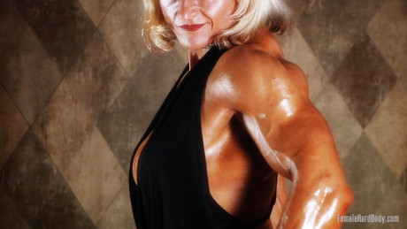 Yellow-haired Slovenian bodybuilder Brigita Brezovac shows her cleavage & hot muscles