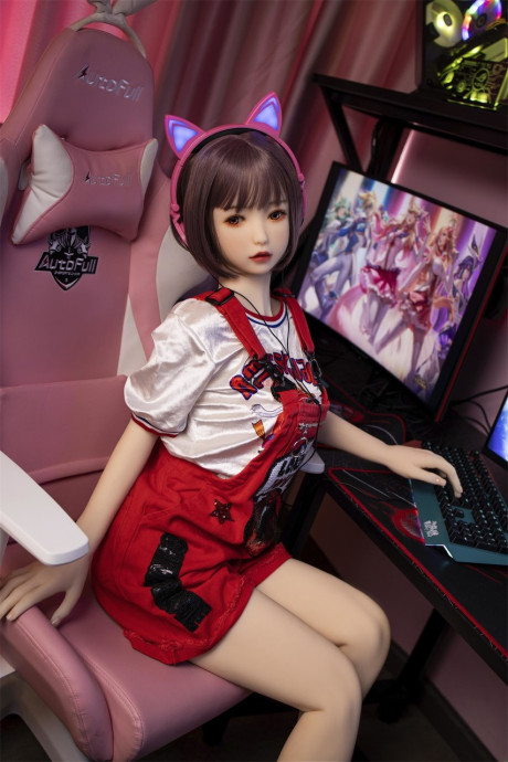 Brunette gamer sex doll Kumi poses undressed and touches her fuckable cunt