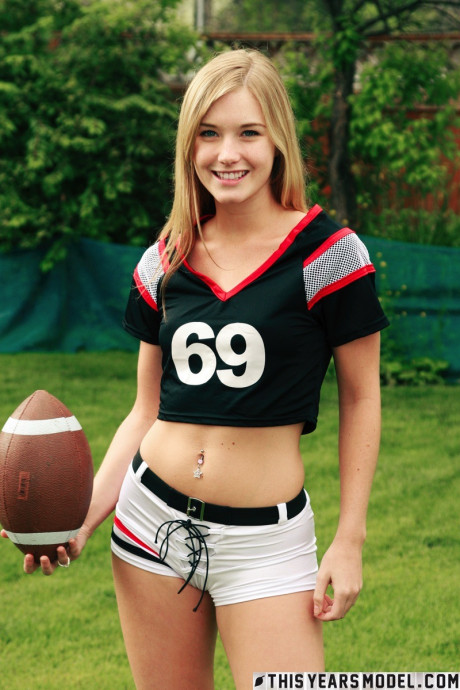 Pretty yellow-haired Jewel doffs sportswear to pose naked while holding a football