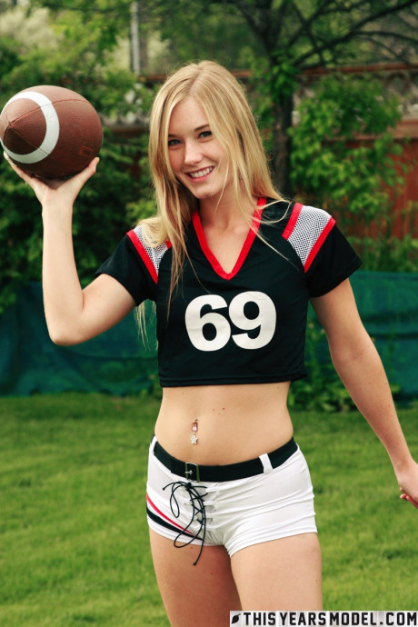 Pretty yellow-haired Jewel doffs sportswear to pose naked while holding a football