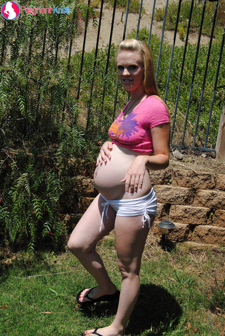 Pregnant amateur Kristi uncovers her milk filled melons and belly bump outdoors
