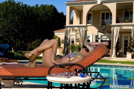 Charming blonde Jana Jordan strips off her bikini top on a sunbed by the pool