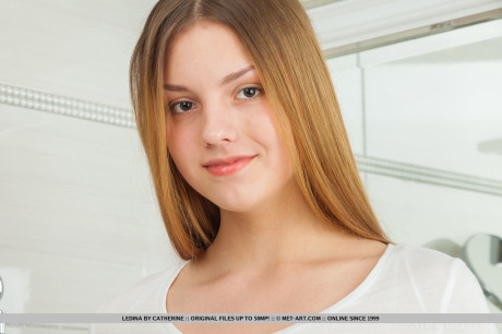 Redheaded babe with great teen legs spreading shaved twat in bathroom