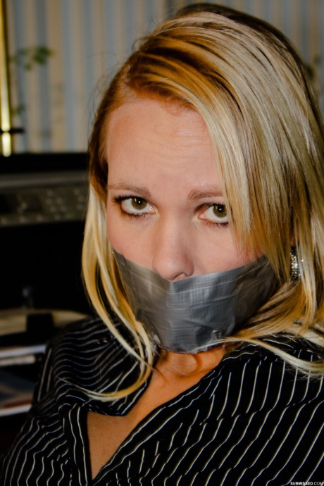 Curvy blonde secretary Natalie posing bound to a rocker at the office