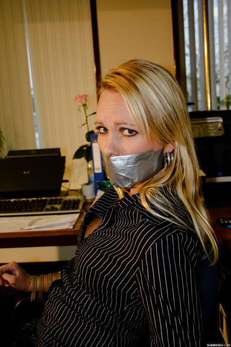 Curvy blonde secretary Natalie posing bound to a rocker at the office