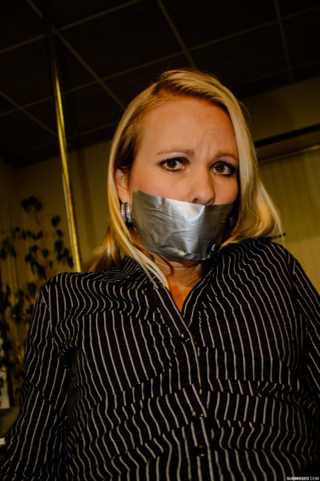 Curvy blonde secretary Natalie posing bound to a rocker at the office