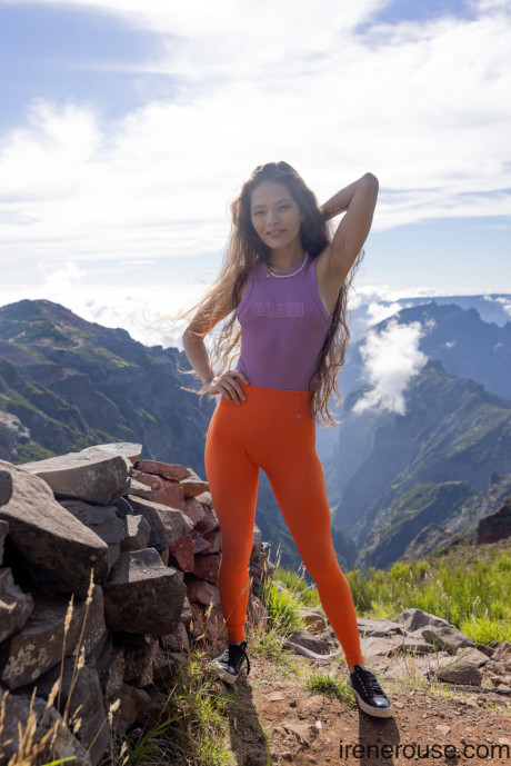 Hispanic Irene Rouse poses in her yoga pants & shirt on a mountian top