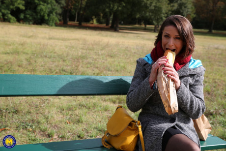 French mom Anya flashes her legs in leggings while eating a sandwich outside