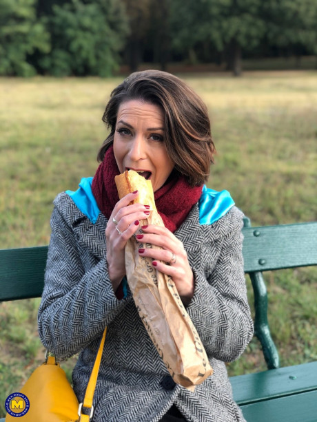 French mom Anya flashes her legs in leggings while eating a sandwich outside