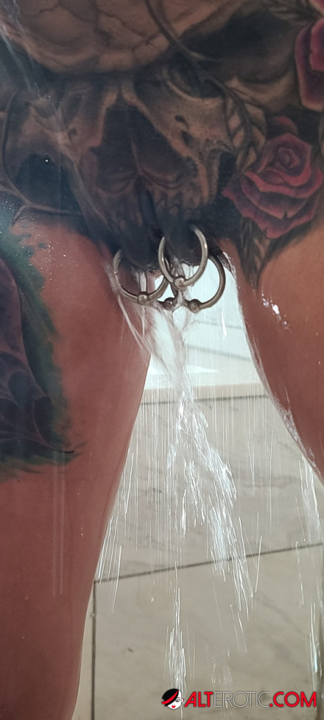 Tatted older chick Marie Bossette highlights her pierced snatch while showering