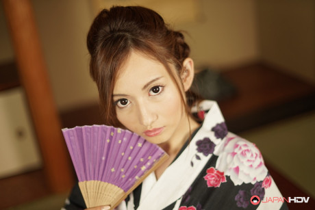 Japanese cutie Reon Otowa holds a fan before getting totally naked