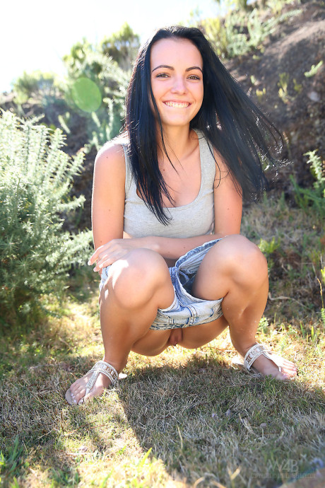 Dark haired chick GF girl finds herself in a field and needing to take a piss