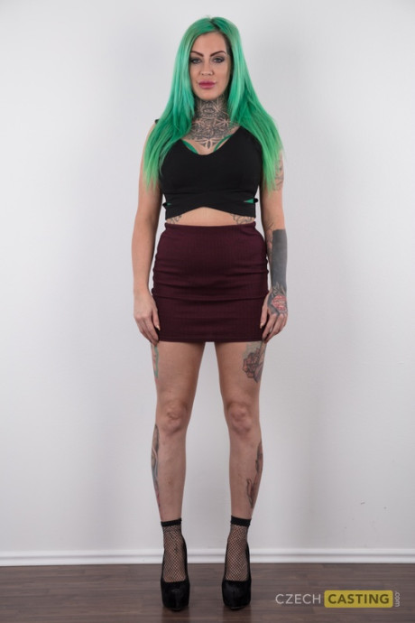 Tattooed girl gf girl with green hair and pierced nipples stands undressed after disrobing