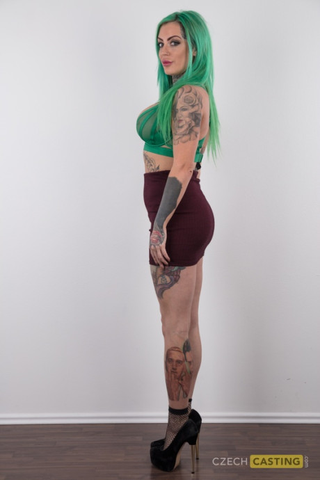 Tattooed girl gf girl with green hair and pierced nipples stands undressed after disrobing