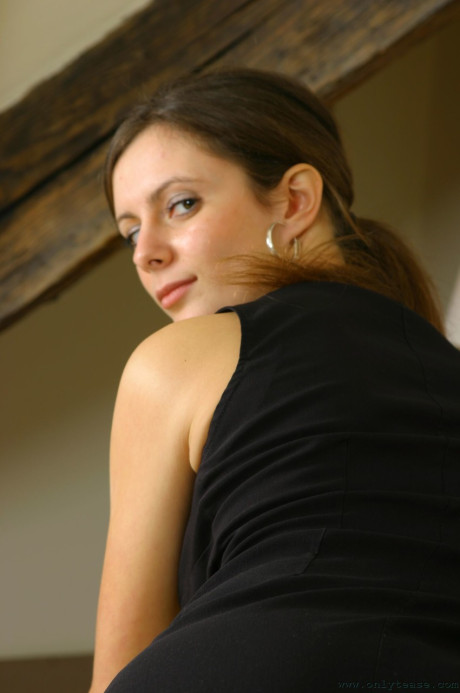 Adorable brunette Martina strips on the bed and poses topless in pantyhose